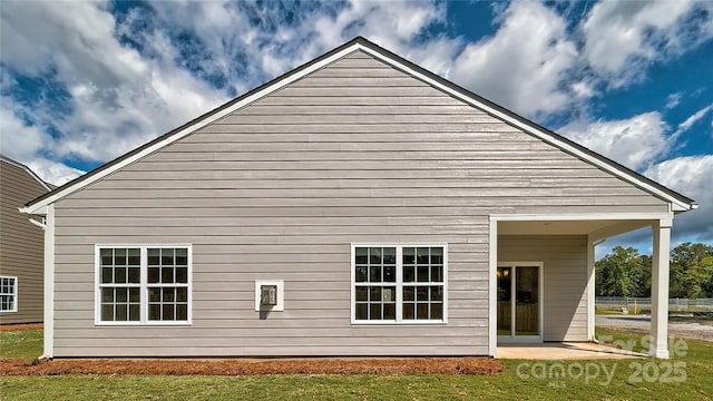 back of property with a patio area and a lawn