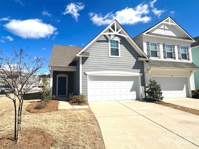 view of front of house featuring a garage, driveway, and a shingled roof