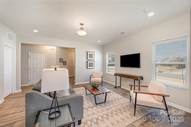 living area featuring recessed lighting, baseboards, and light wood finished floors