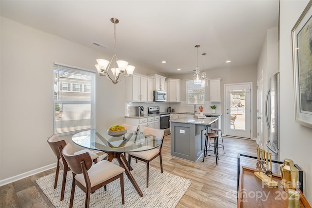 dining room featuring light wood finished floors, visible vents, recessed lighting, and baseboards