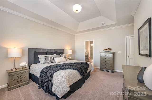 bedroom featuring baseboards, ensuite bath, ornamental molding, a raised ceiling, and light colored carpet