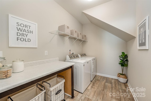 laundry area featuring washing machine and clothes dryer, laundry area, light wood-style flooring, and baseboards