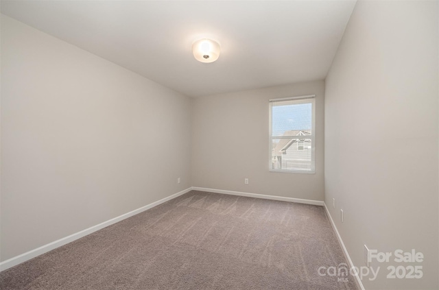 carpeted spare room with baseboards