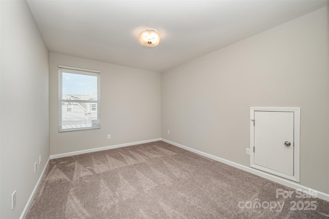 unfurnished room with baseboards and carpet floors