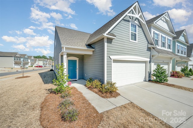 view of front of house featuring a residential view, an attached garage, concrete driveway, and a shingled roof