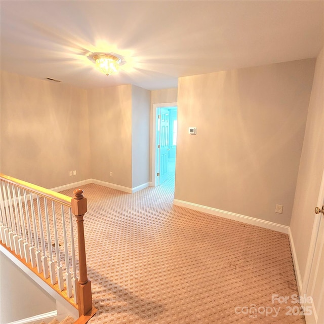 carpeted empty room with stairs, visible vents, and baseboards