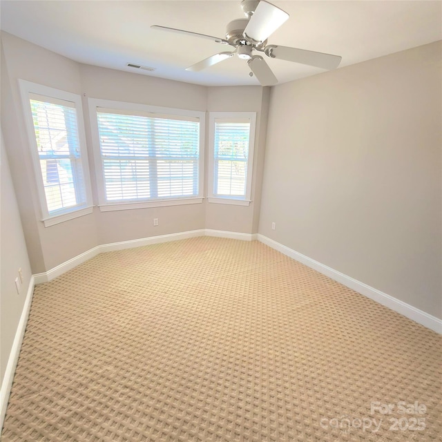 empty room featuring visible vents, baseboards, and light carpet