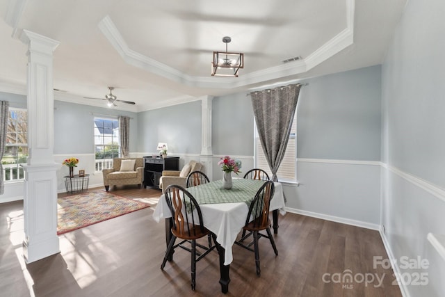 dining space with visible vents, ornamental molding, wood finished floors, and decorative columns