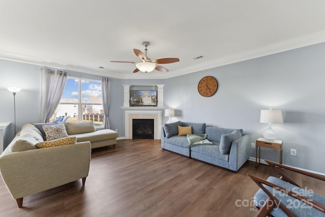 living area with dark wood-style floors, a fireplace, baseboards, and crown molding