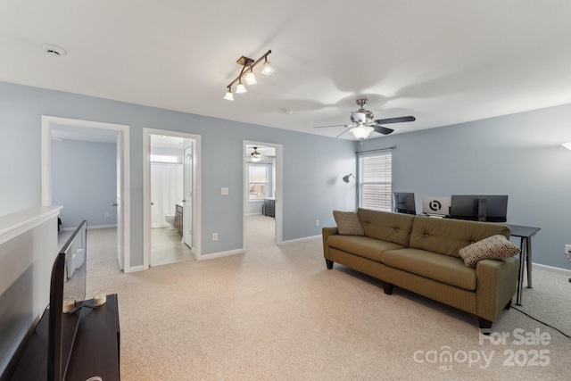 living room with baseboards, a ceiling fan, and light colored carpet