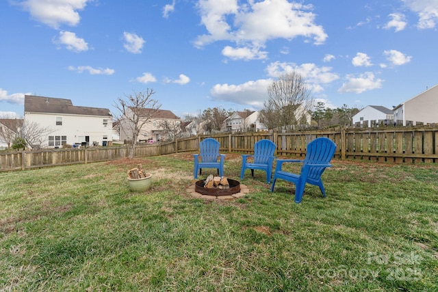 view of yard with a residential view, a fenced backyard, and a fire pit