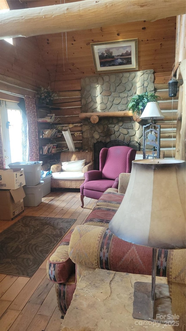 living room featuring log walls, vaulted ceiling, and hardwood / wood-style flooring