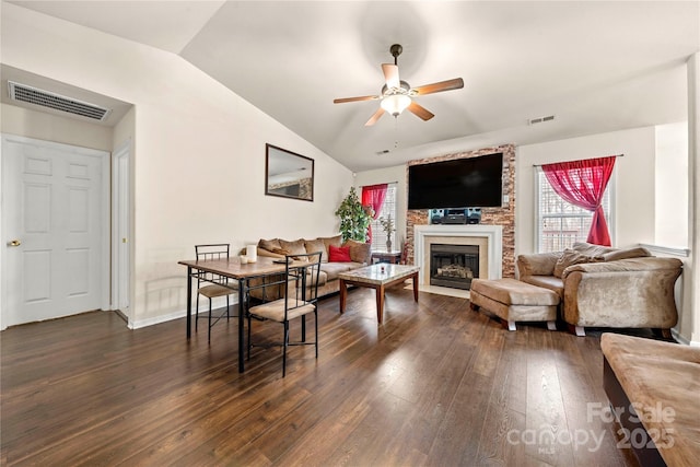 living area featuring vaulted ceiling, visible vents, dark wood-style flooring, and ceiling fan
