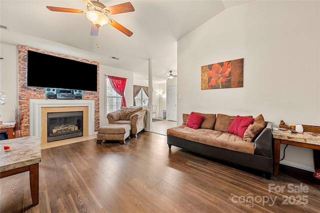 living area with visible vents, lofted ceiling, ceiling fan, and wood finished floors