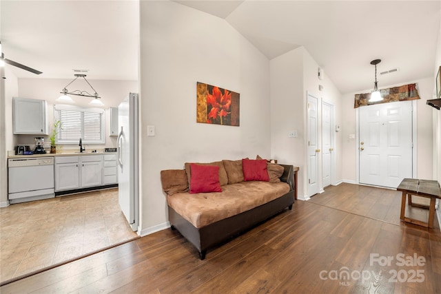 living room featuring visible vents, ceiling fan, lofted ceiling, and wood-type flooring
