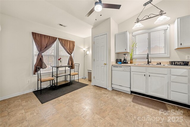 kitchen featuring visible vents, white dishwasher, ceiling fan, a sink, and light countertops