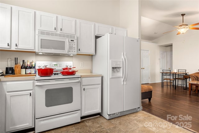 kitchen with white appliances, ceiling fan, vaulted ceiling, light countertops, and white cabinetry