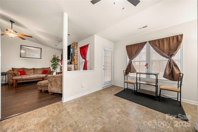 foyer entrance featuring baseboards, visible vents, ceiling fan, vaulted ceiling, and stone finish floor