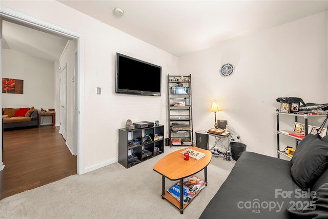 carpeted living room with baseboards