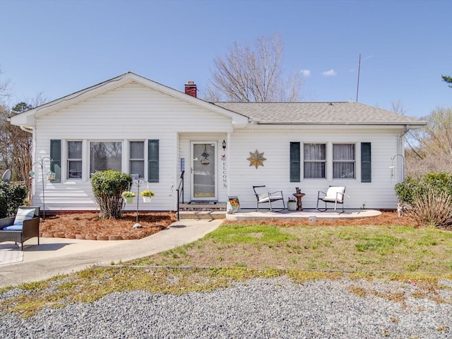 single story home featuring roof with shingles and a chimney