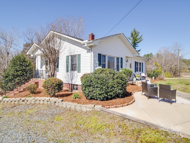 single story home with a chimney and a patio