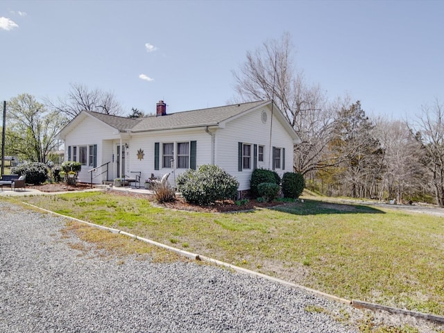 ranch-style home with a chimney and a front lawn