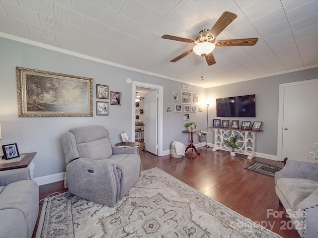 living room with ceiling fan, baseboards, wood finished floors, and crown molding