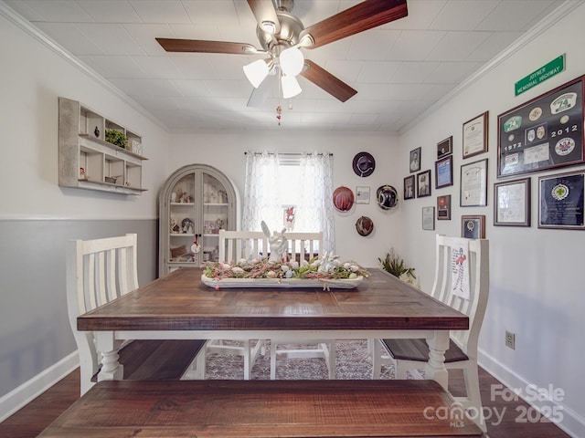 dining space featuring crown molding, wood finished floors, baseboards, and ceiling fan