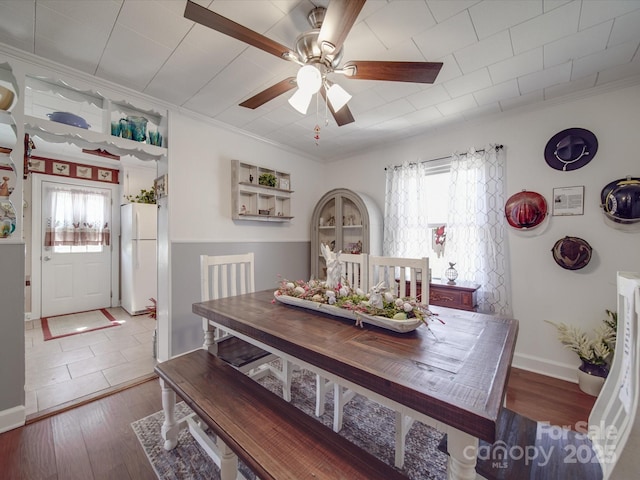 dining room featuring plenty of natural light, wood finished floors, a ceiling fan, and ornamental molding