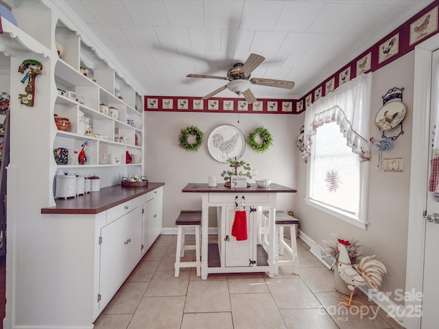 kitchen with dark countertops, light tile patterned floors, a ceiling fan, and open shelves