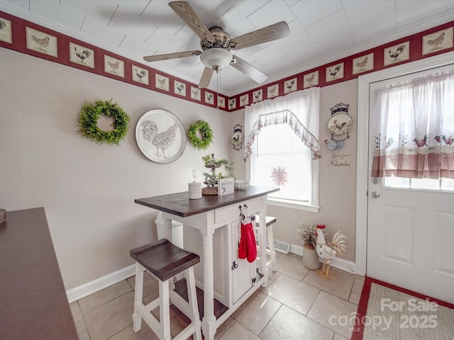 foyer featuring visible vents, light tile patterned flooring, a ceiling fan, and baseboards