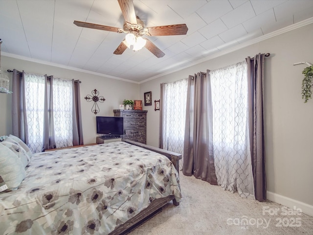 bedroom with crown molding, carpet flooring, a ceiling fan, and baseboards