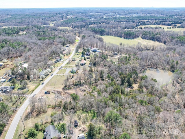 birds eye view of property with a view of trees and a water view