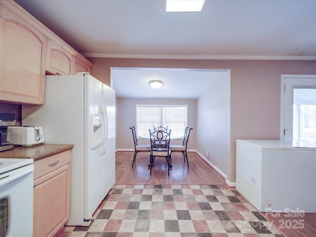 kitchen with light brown cabinets, white appliances, baseboards, and ornamental molding