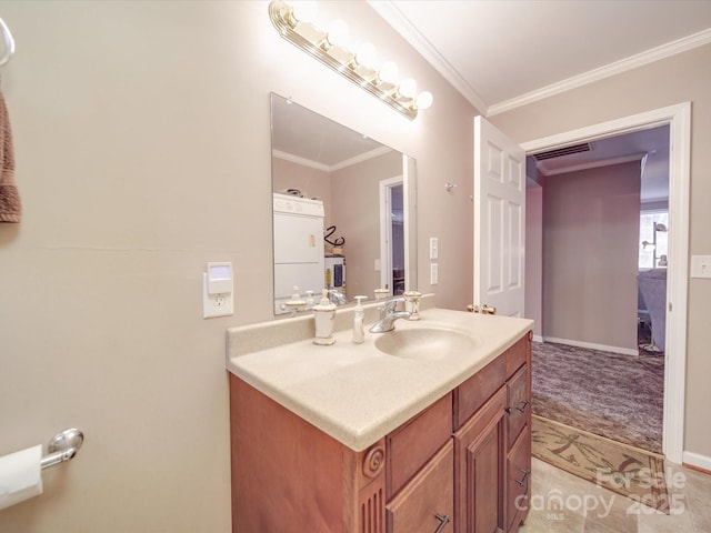 bathroom featuring vanity, crown molding, washer / clothes dryer, and baseboards