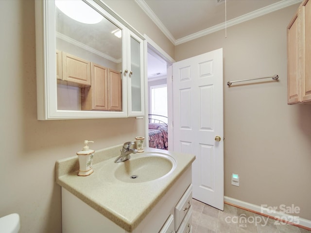 bathroom featuring vanity, crown molding, and baseboards