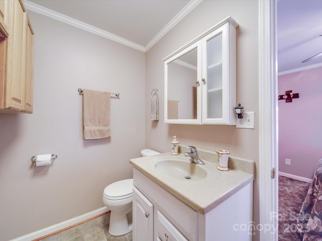 bathroom with baseboards, toilet, ornamental molding, and vanity