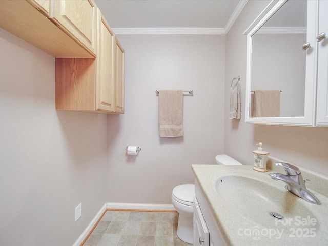 half bathroom featuring vanity, toilet, crown molding, and baseboards