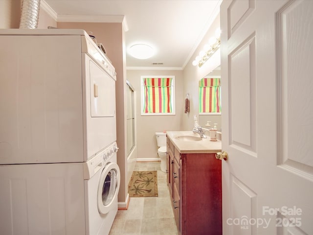 bathroom featuring stacked washer / dryer, toilet, crown molding, and visible vents