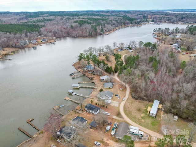 aerial view with a water view and a wooded view