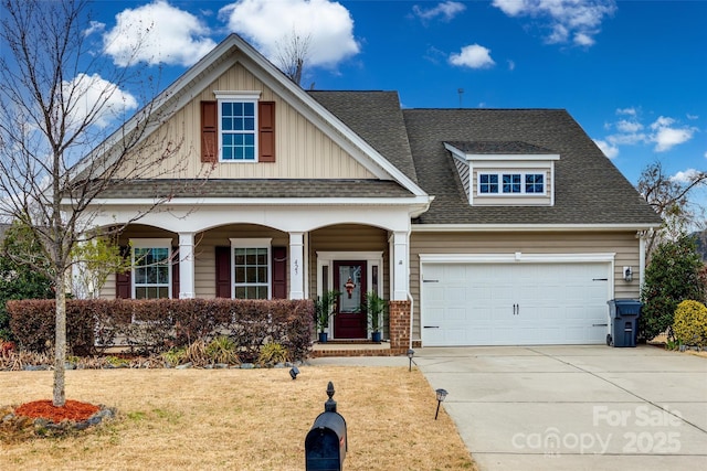 craftsman inspired home with driveway, covered porch, a shingled roof, a front lawn, and a garage