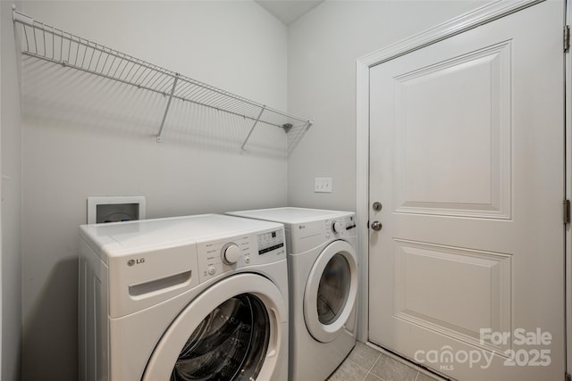 laundry room with washer and dryer, laundry area, and light tile patterned flooring