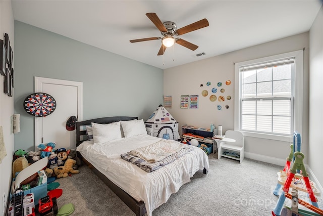 carpeted bedroom with a ceiling fan, baseboards, and visible vents