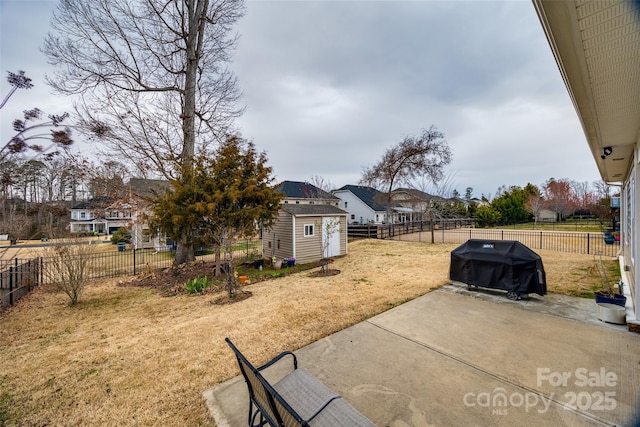 view of yard featuring an outbuilding, a patio area, a fenced backyard, and a shed