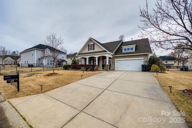 view of front facade with a porch, concrete driveway, fence, and a front lawn