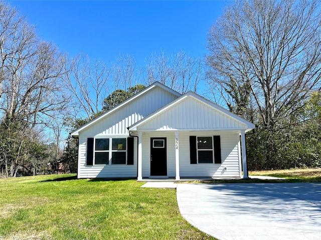 view of front of house with board and batten siding, covered porch, and a front lawn