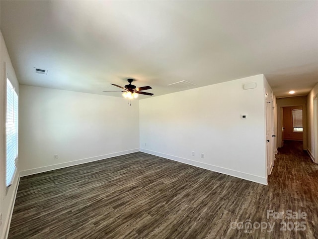 unfurnished room with a ceiling fan, baseboards, visible vents, and dark wood-type flooring