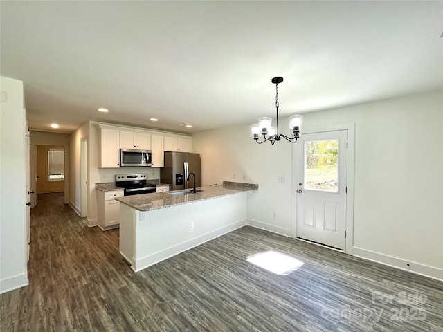 kitchen featuring baseboards, dark wood finished floors, white cabinets, appliances with stainless steel finishes, and a peninsula