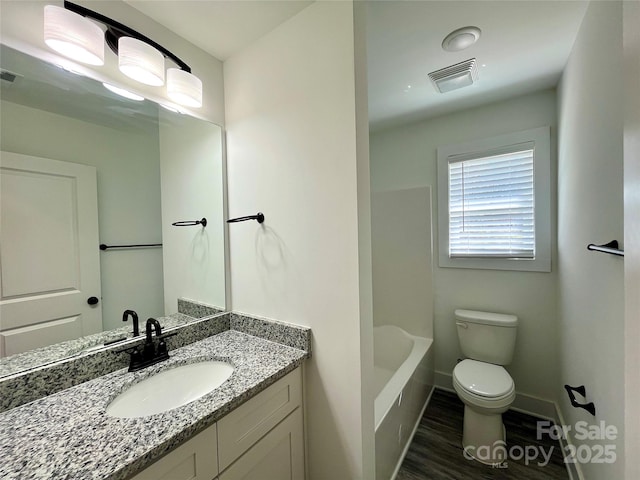 full bath featuring baseboards, visible vents, toilet, wood finished floors, and vanity