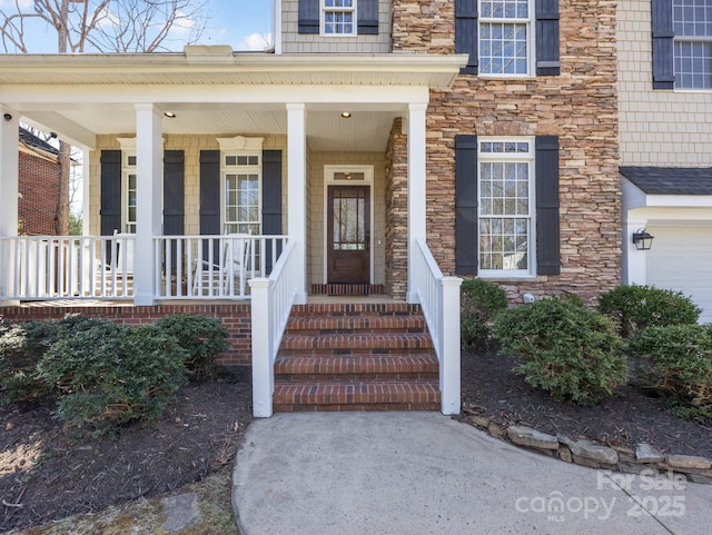 view of exterior entry with stone siding and a porch